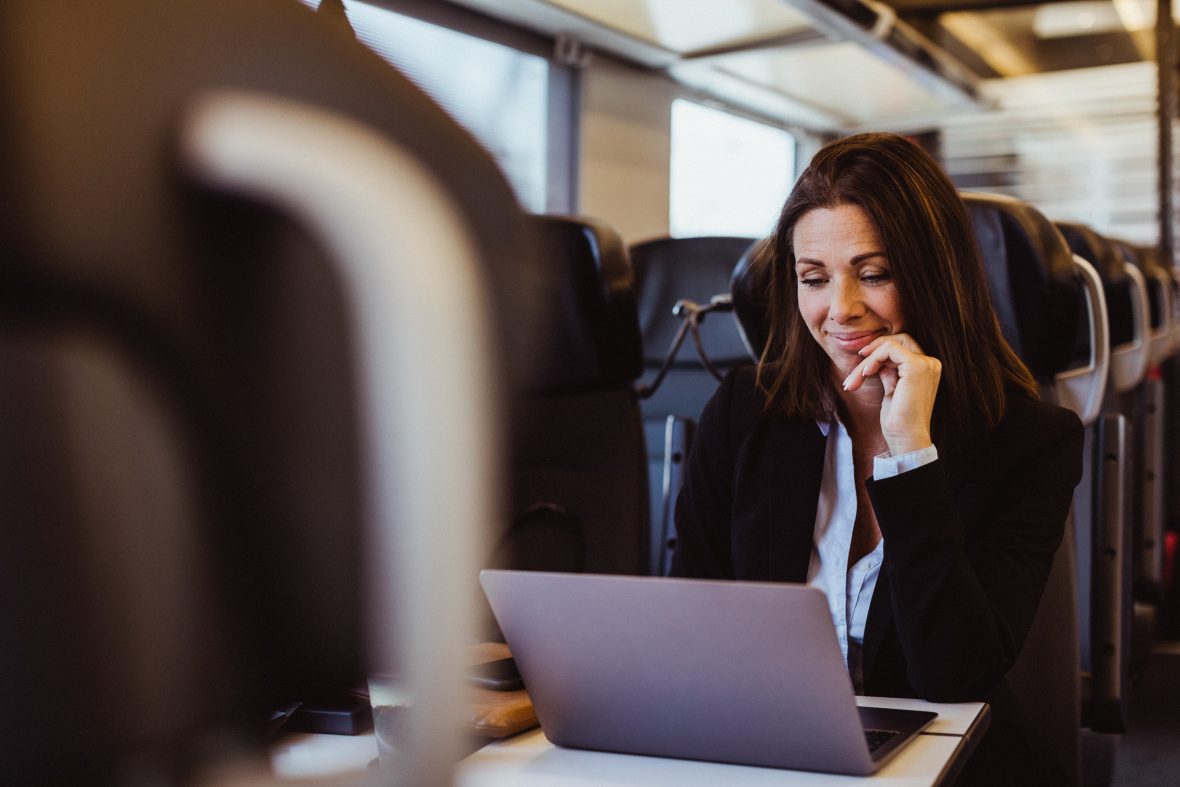 kvinna som arbetar vid dator på tåg