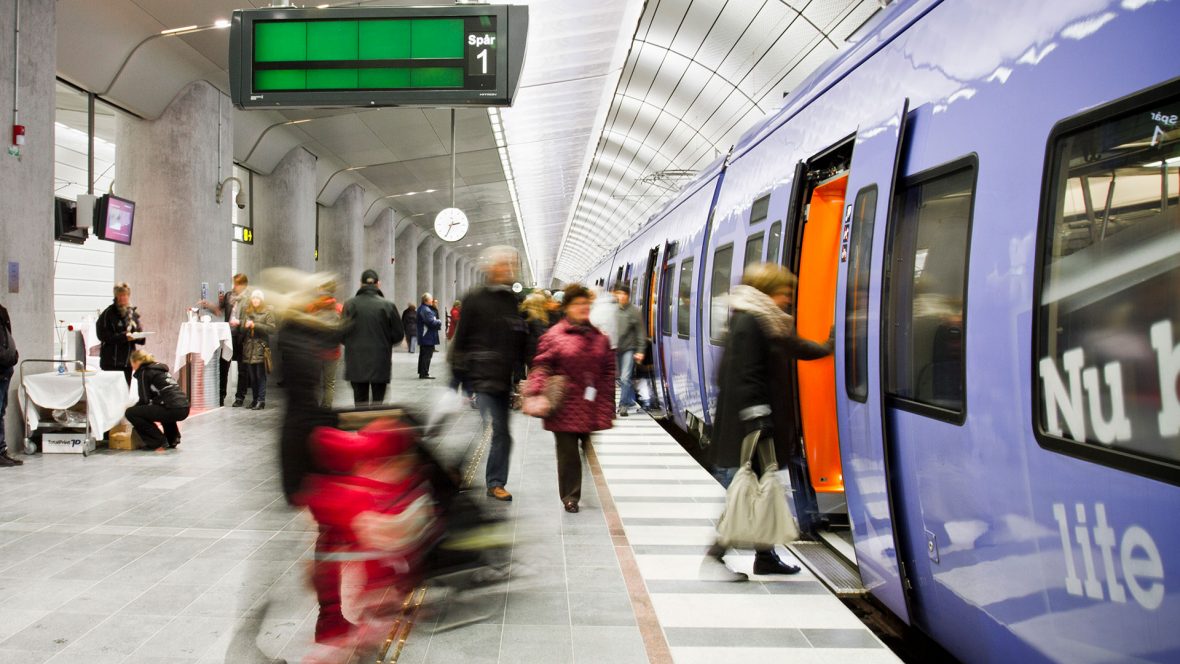 personer går på tåg vid perrong