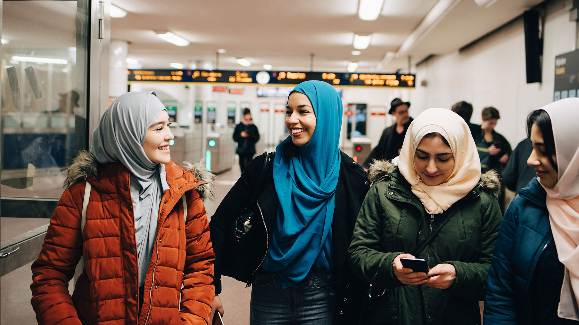 fyra tjejer gåendes från tunnelbanespärren
