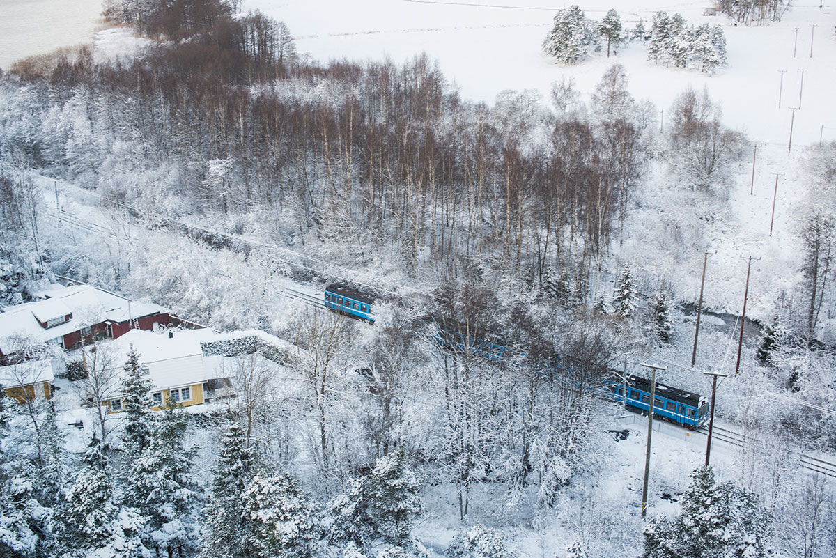tåg ovanifrån åker förbi hus på vintern